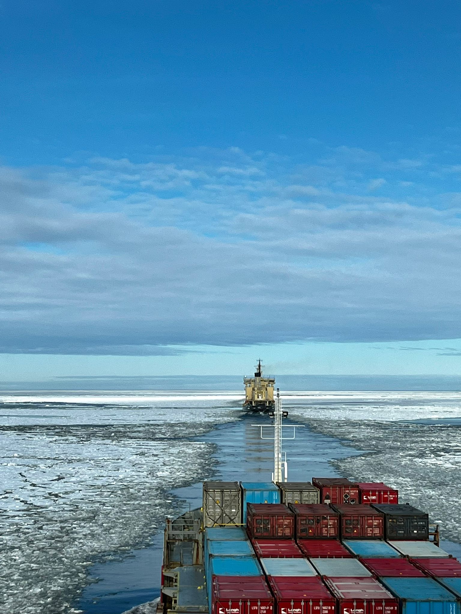 cargo ship traveling through melting ice sea in Gulf of Bothnia