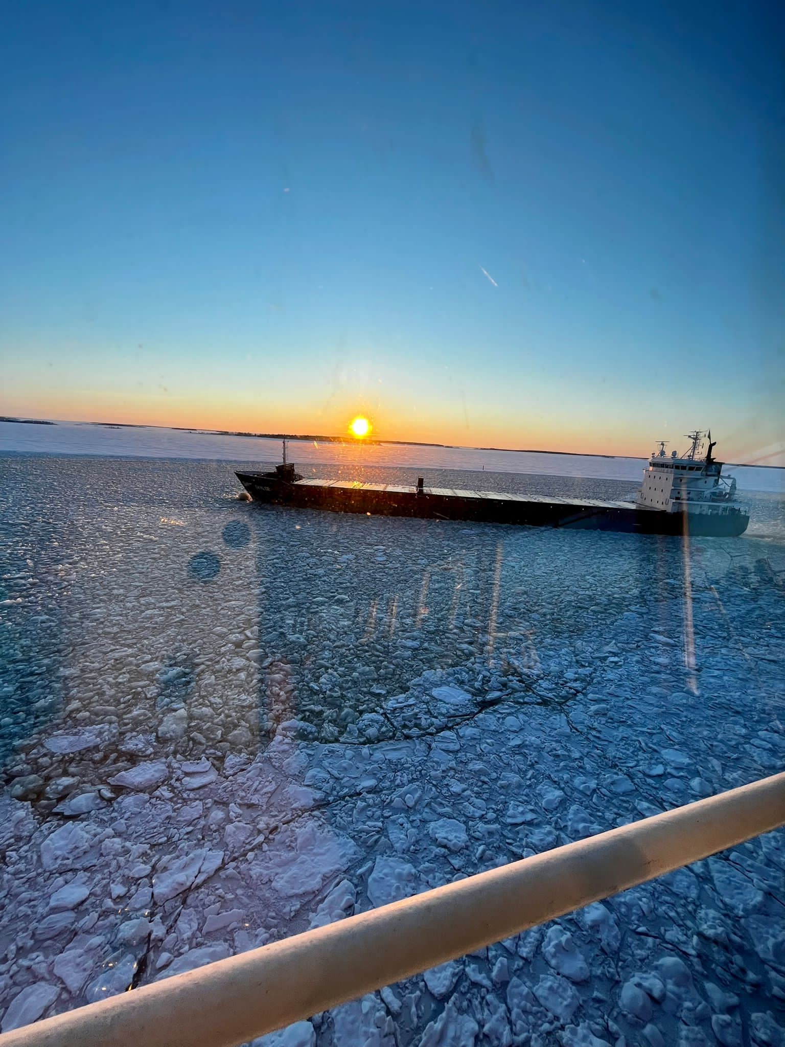 view of empty cargo ship traveling through ice in Gulf of Bothnia