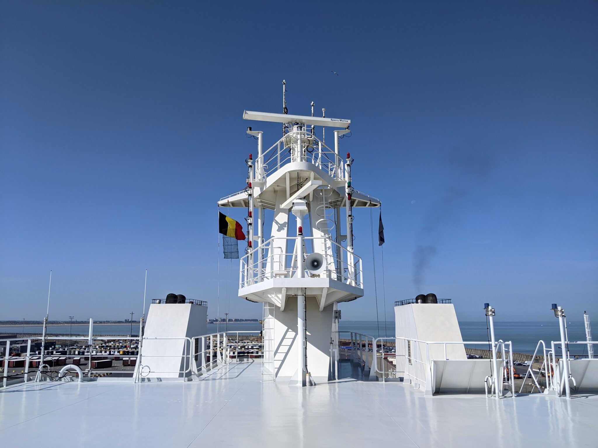 Finneco III container schip achterste deel met zicht op blauwe lucht en met belgische vlag