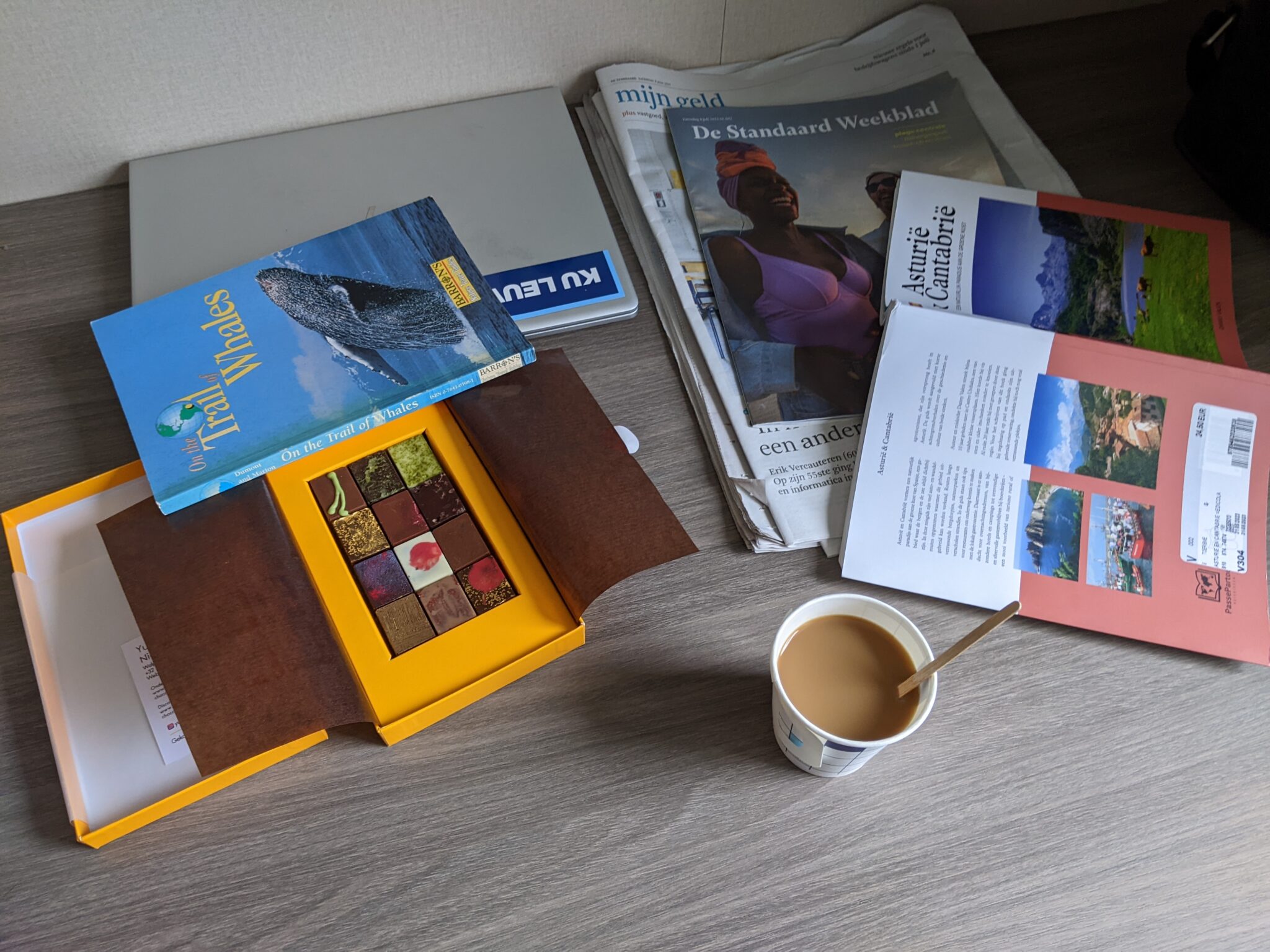 beeld van bureautafel in schip met boeken, koffie en pralines