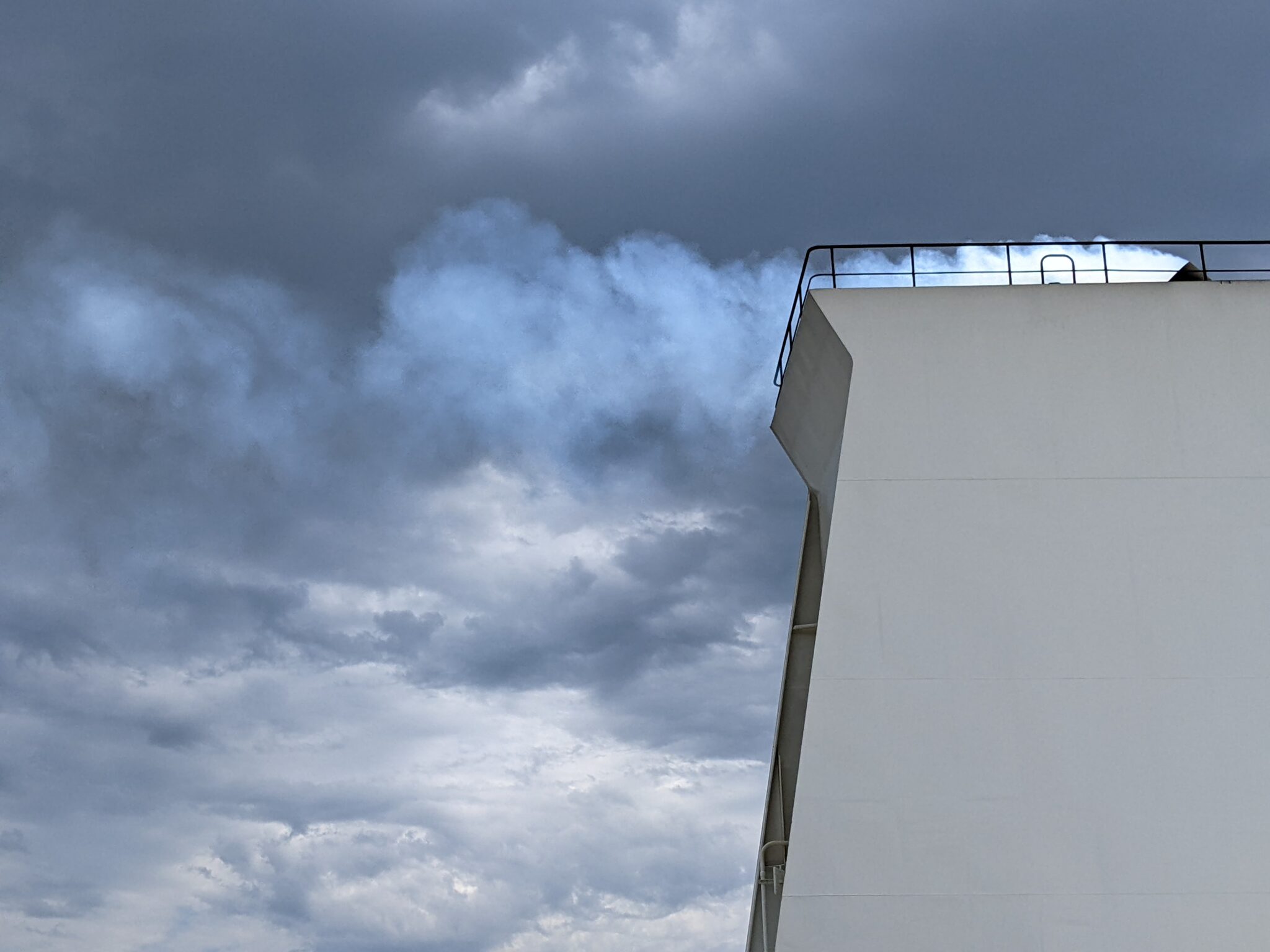 toren op containerrschip met zwarte wolken op achtergrond