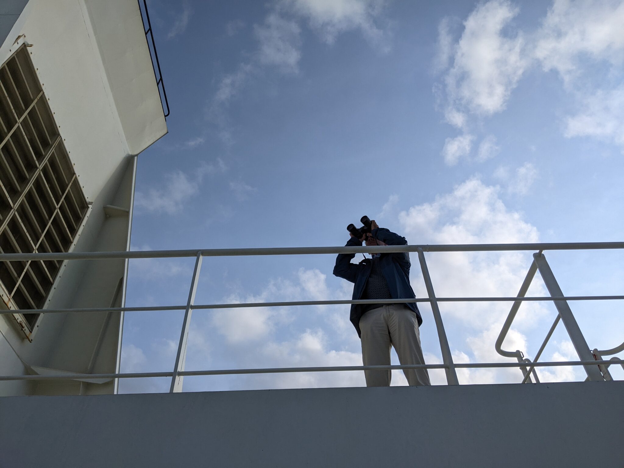 man kijkt door verrekijkers aan boord van cargo schip