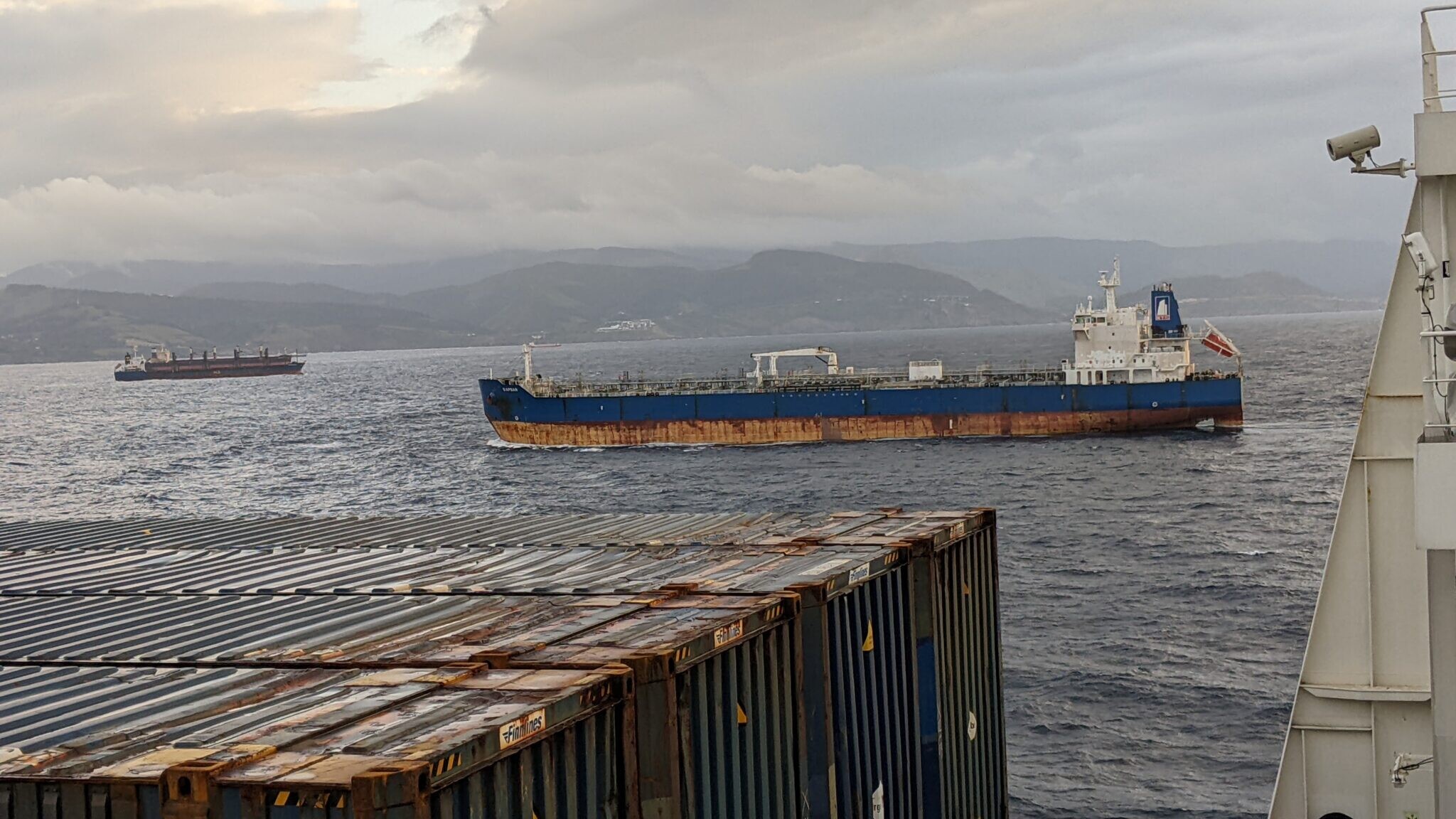 beeld vanop container schip met zee en bilbao in zicht